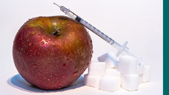 A syringe, an apple, and sugar on a white background are symbolizing insulin resistance